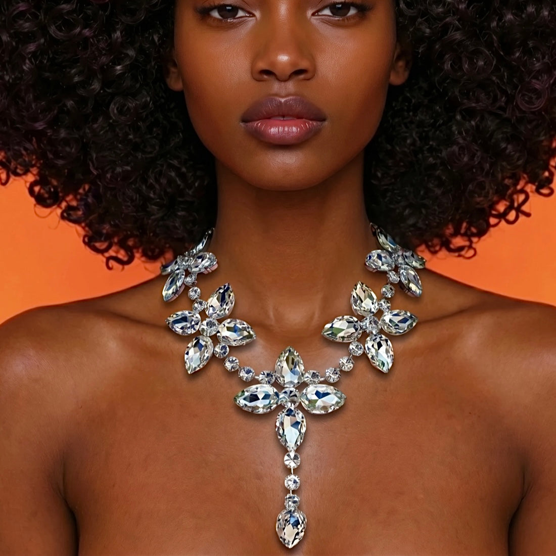 Woman wearing a sparkling necklace against an orange background