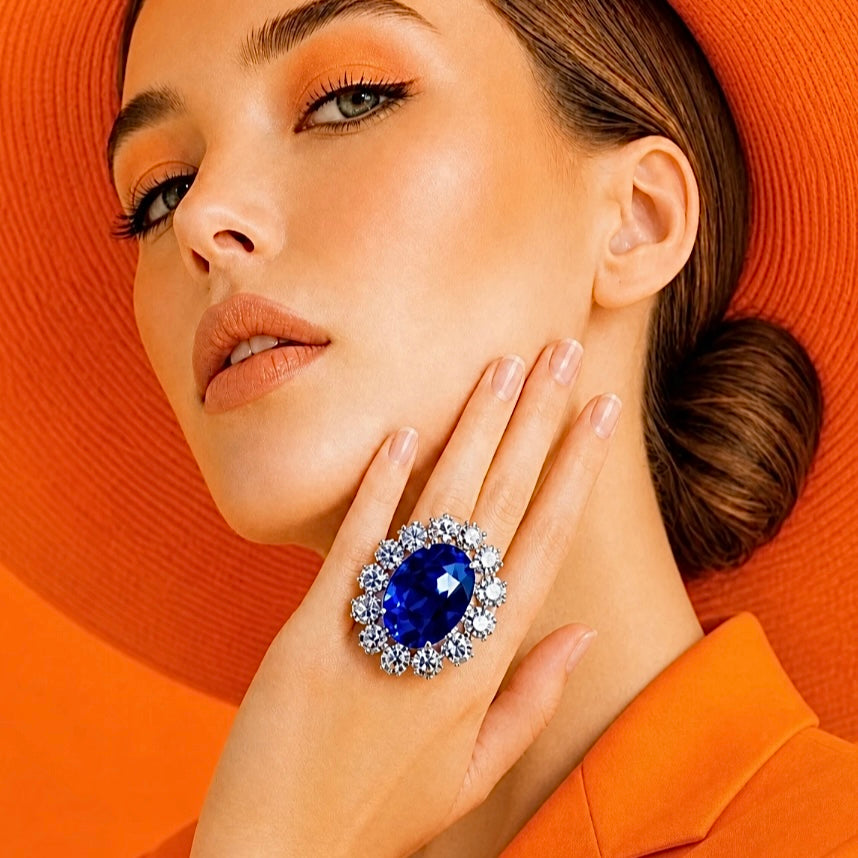 Woman wearing a blue gemstone ring against an orange background