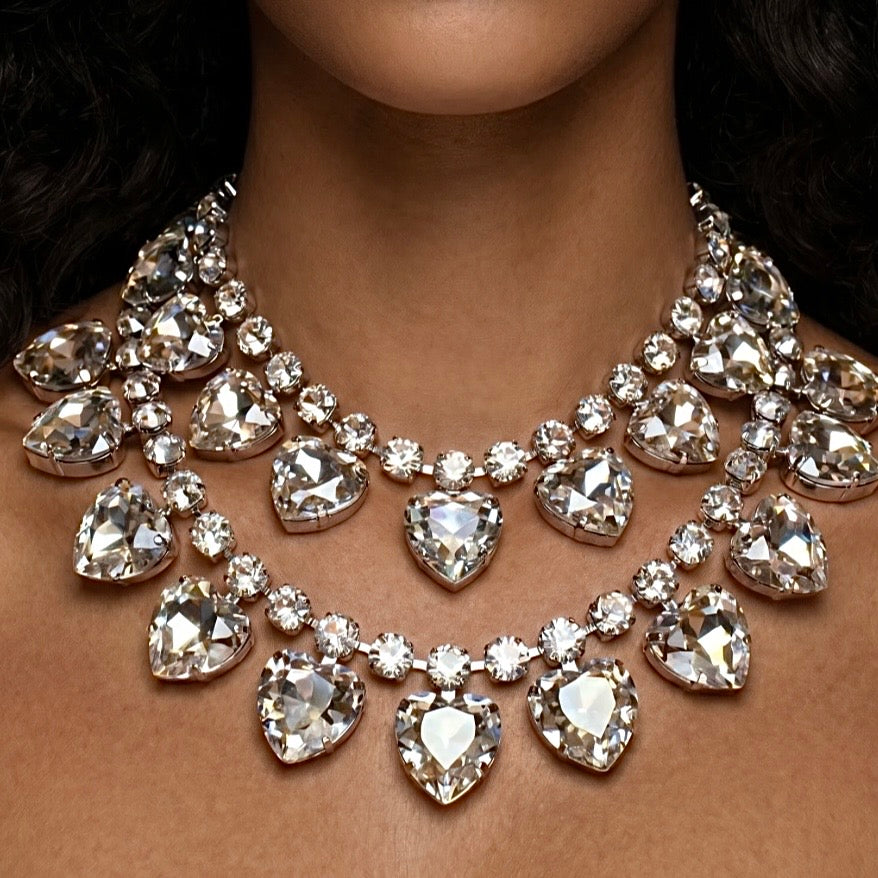 Close-up of a sparkling necklace with heart-shaped crystals on a person's neck.